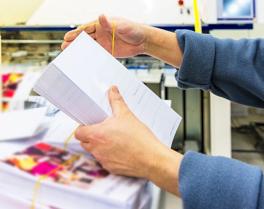 A person sorting stacks of printing