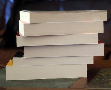 A stack of six softcover books