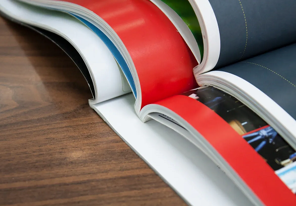 Three open Perfect Bound books stacked on a table