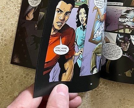 A male hand flipping the pages of a colorful comic book