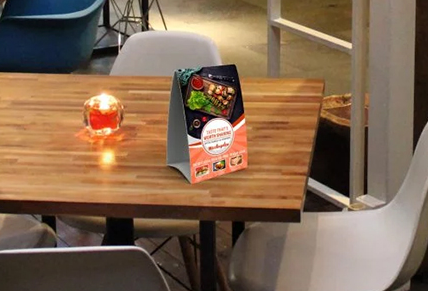 A promotional Table Tent sitting on a table in a restaurant