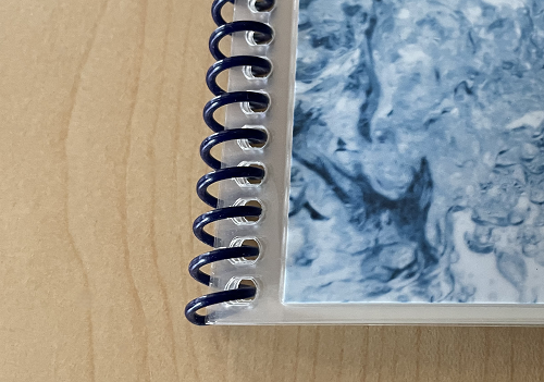 A waterproof book with laminated pages and plastic coil binding