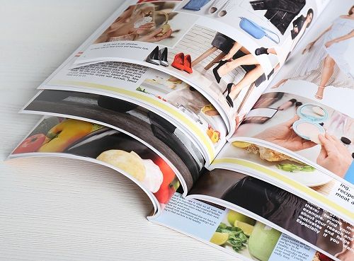 A stack of colorful magazines lying open on a table