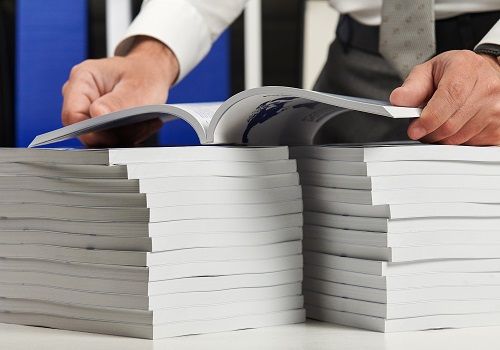 A man inspecting a stack of newly printed Perfect Bound books