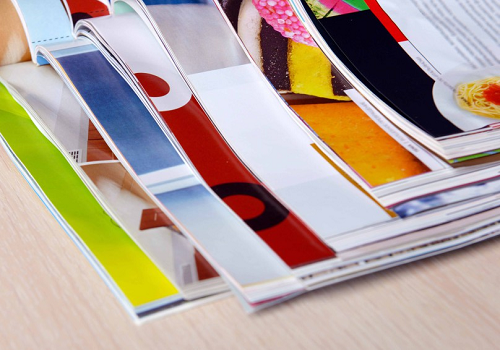 A stack of magazines with Aqueous Coated pages 