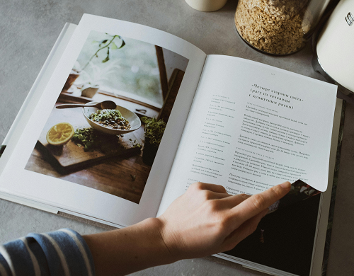 A person turning the page of a cookbook