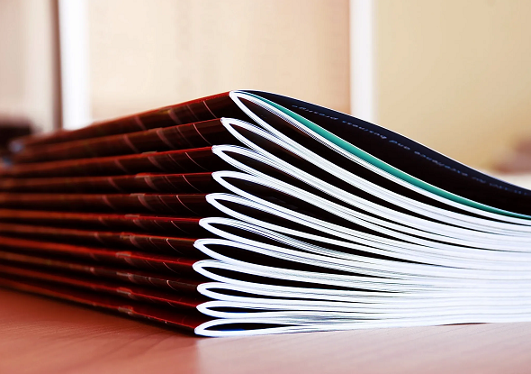 A stack of Saddle Stitched Booklets lying on a desk