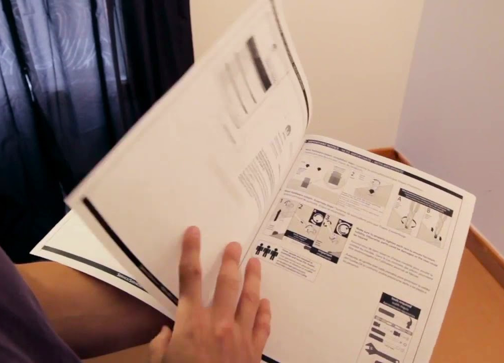 A man reading a saddle stitched Instruction Booklet
