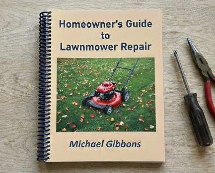 A spiral bound lawnmower repair book lying on a gray wooden tabletop next to a Phillips screwdriver and a pair of long nose pliers