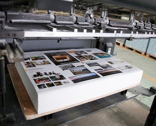 Newly printed parent sheets having just exited a sheet-fed offset press.