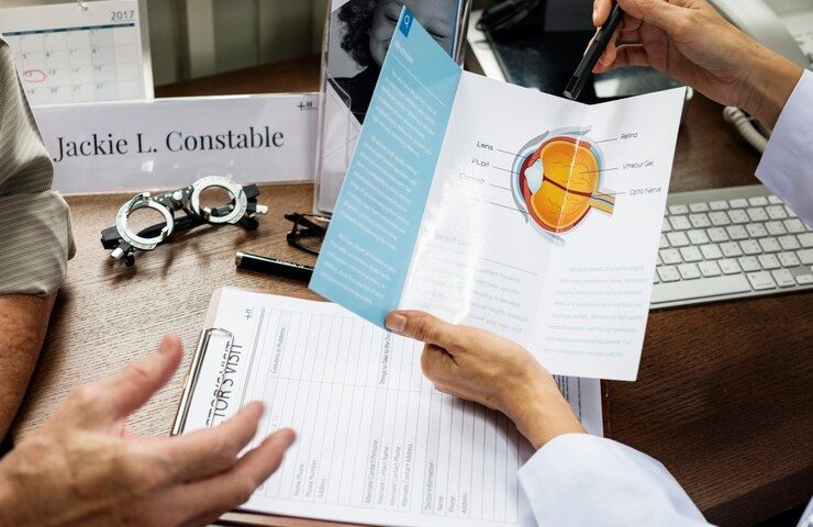 An eye doctor showing a pamphlet to a patient