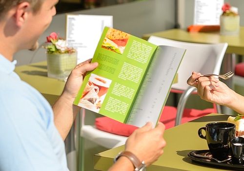 A man reading a menu in a restaurant 