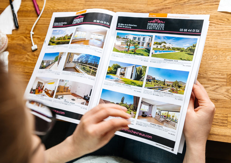 A person reading through a real estate catalog