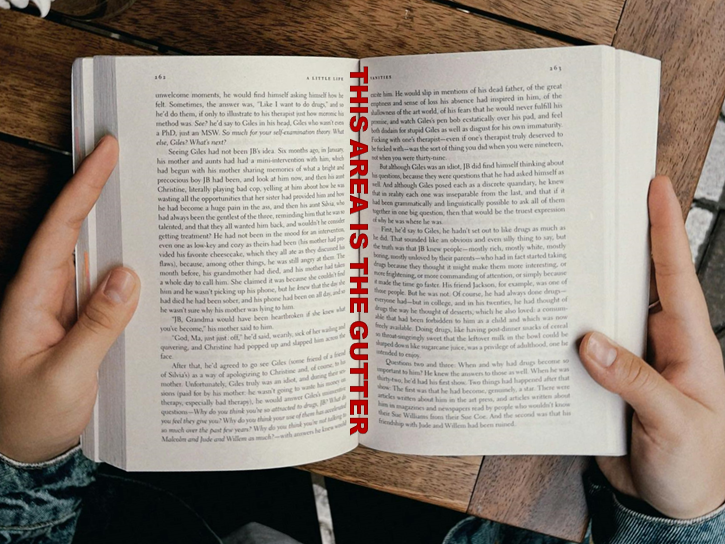 A person holding open a book to display the book's gutter area