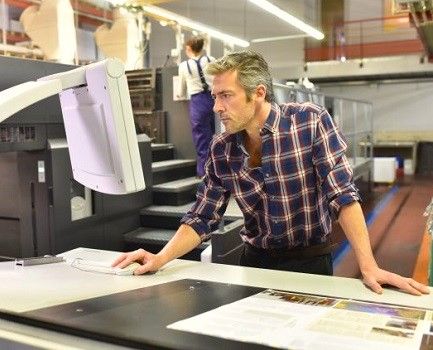 Press operators prepare an offset press for a production run