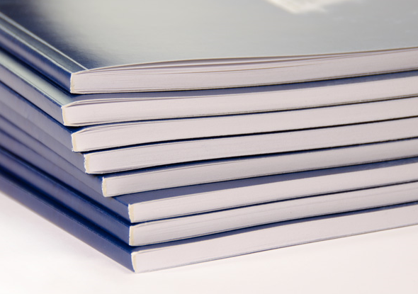 A stack of Perfect Bound Books with blue covers