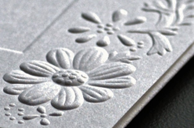 Floral pattern embossed on a light colored substrate