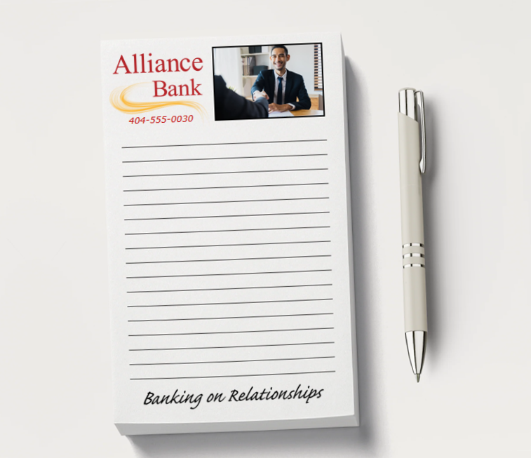 A promotional notepad and a pen lying on a white tabletop