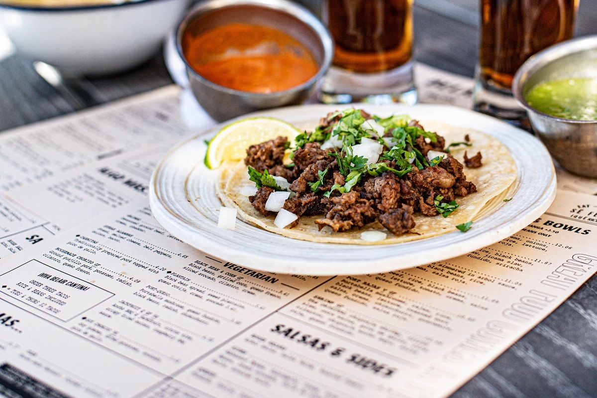 Two restaurant menus lying underneath a plate of food