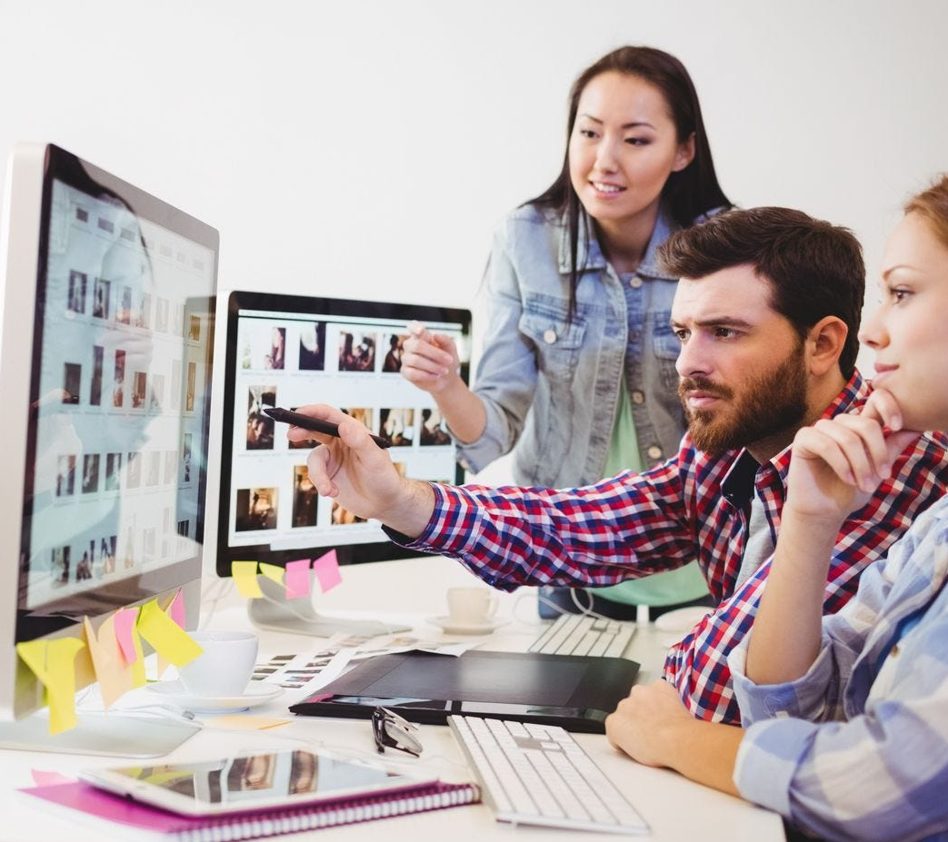 A graphics team discussing  a print project 