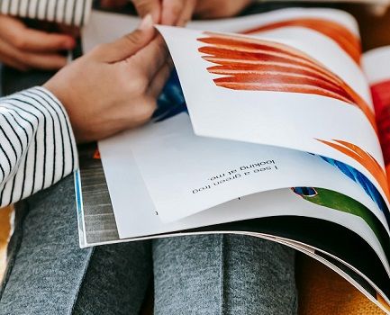 The hands of a child turning the colorful pages of a large picture book