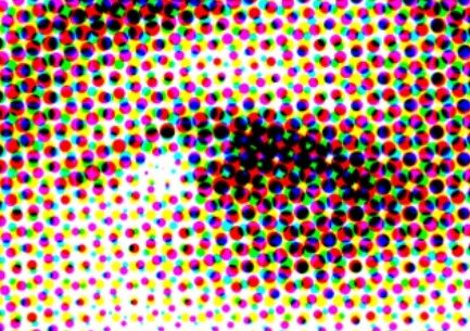 A close up view of the CMYK ink dots on a paper sheet