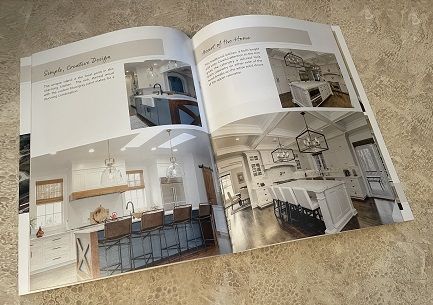 A booklet catalog for a kitchen remodeling company lying open on a counter