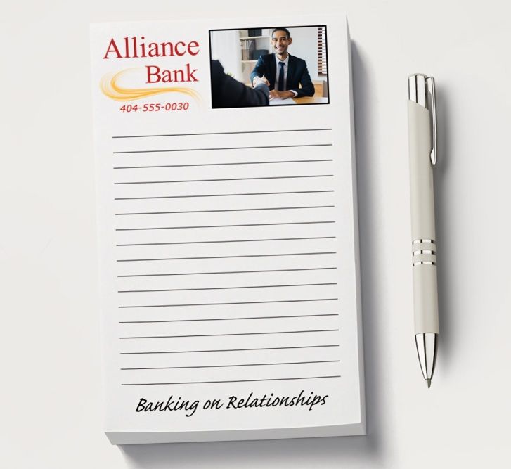 A promotional notepad and a pen lying on a white table