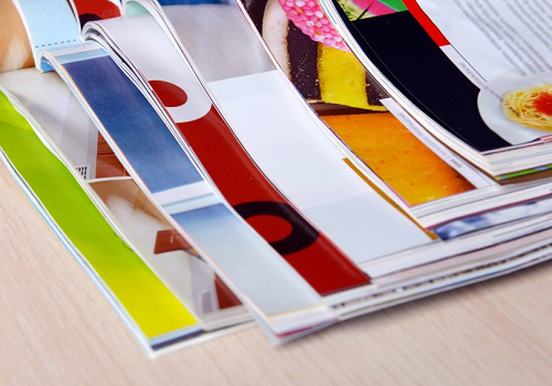 Colorful magazines lying open in a stack 