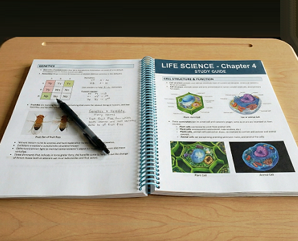 A life science study guide lying open on a classroom desk