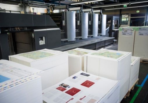 Printed sheets stacked in front of an offset printing press