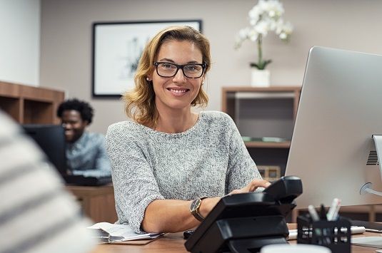 A female office worker picking up the phone