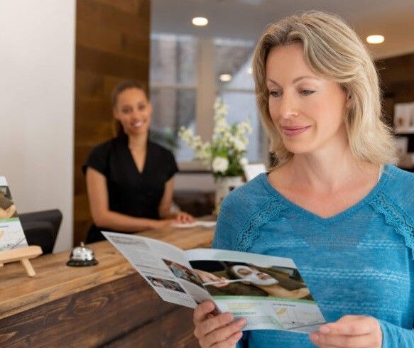A woman reading a brochure about spa services