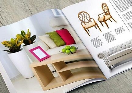 A Booklet Catalog for a home furnishings company lying open on a gray wooden table