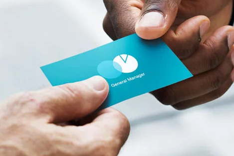 Two male hands exchanging a blue business card