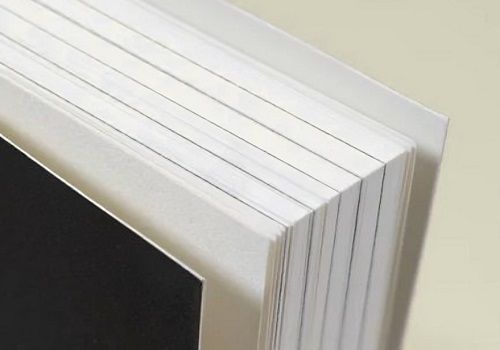 A close-up view of a softcover book showing the page block and a heavy cardstock cover. 