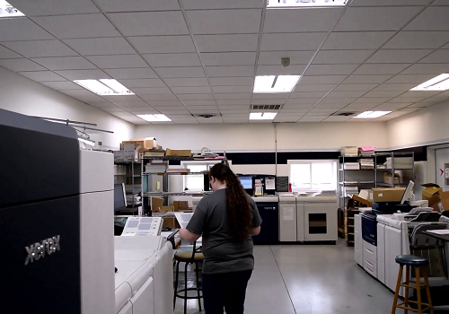 The Digital Printing Department at Color Vision Printing showing a female press operator and three Xerox digital printing presses.