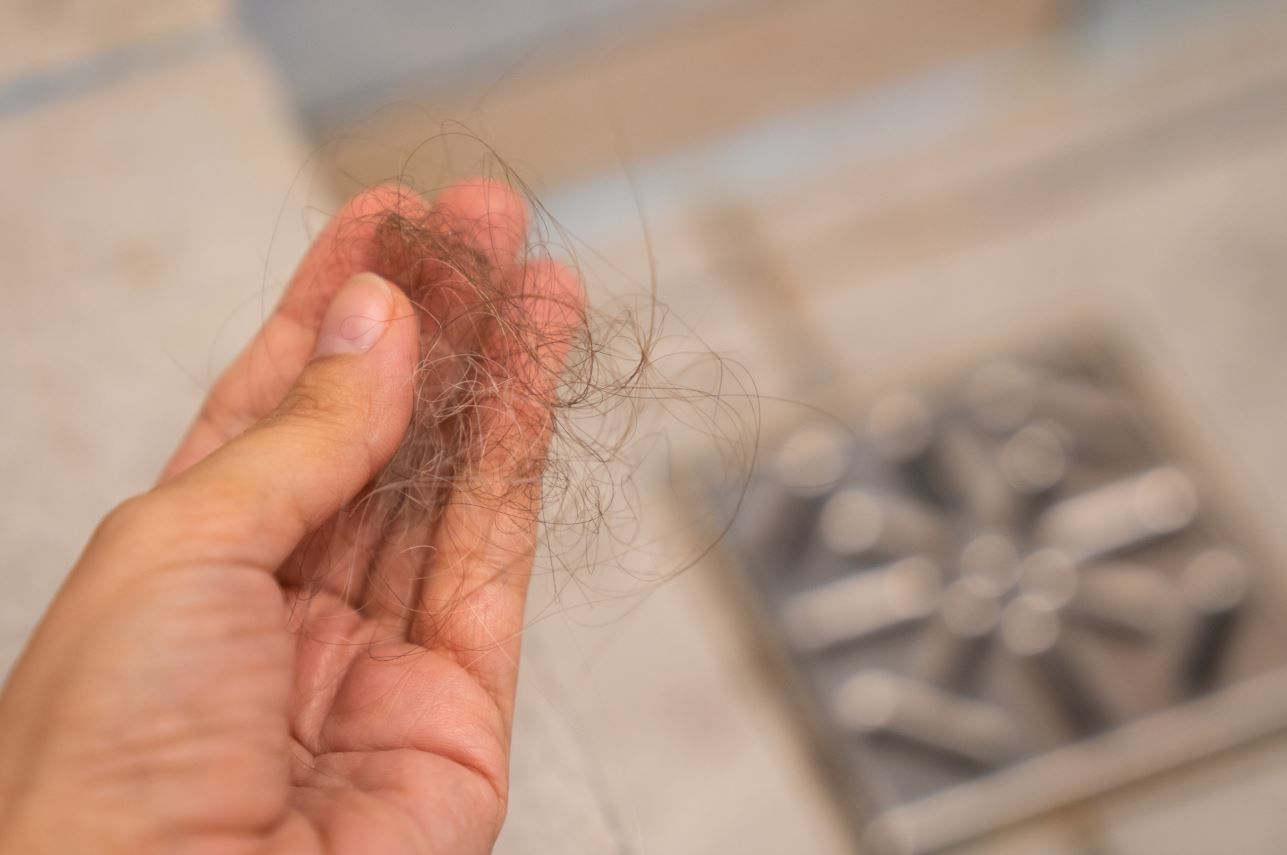 Hair in a hand, a potential reason for clogged drains