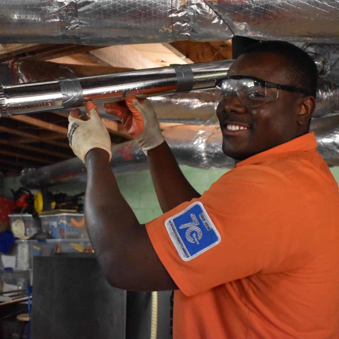 Estes Plumber Smiling while he is installing a Rheem Tank Water Heater