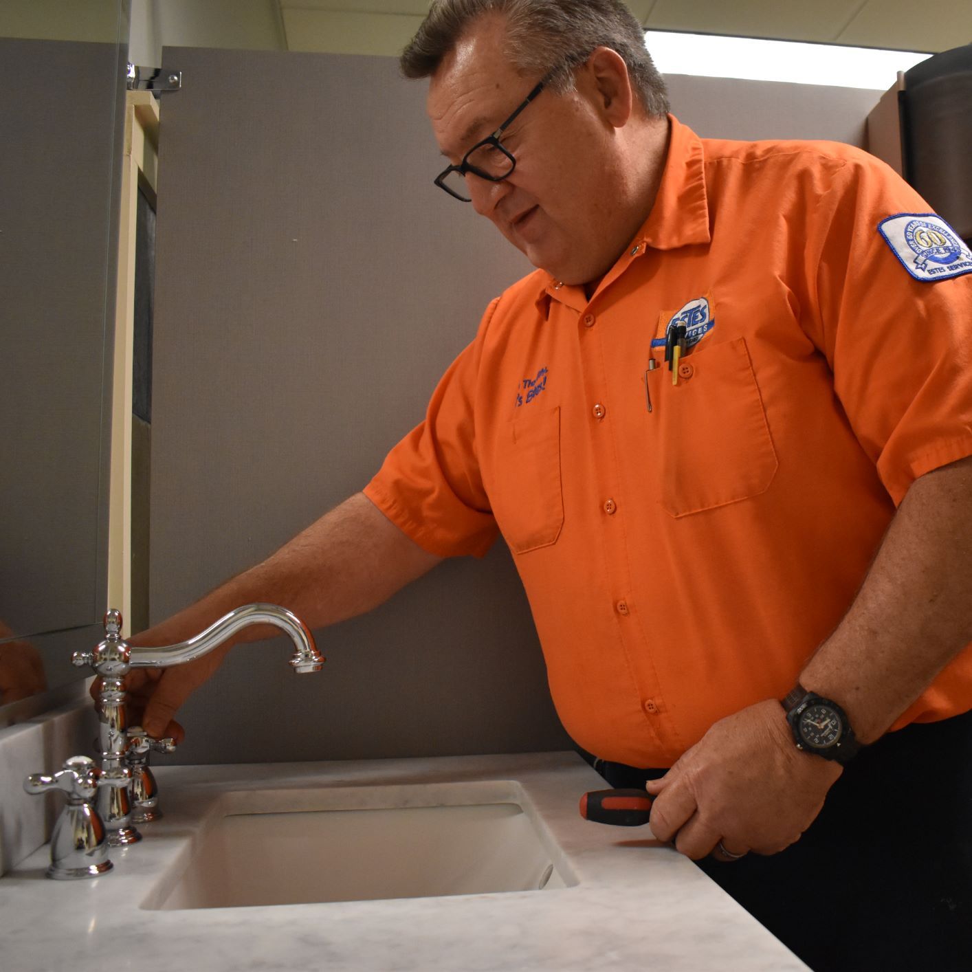 Estes Plumber in a bathroom, fixing plumbing fixtures 