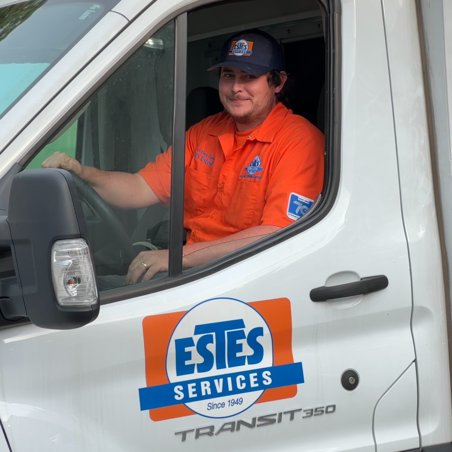 Estes plumber wearing and uniform and driving an Estes Services Truck