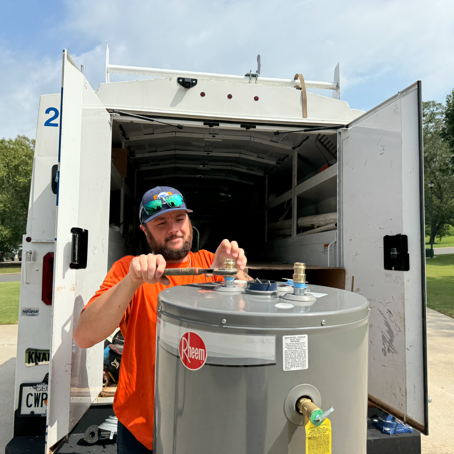 Estes Plumber installing a Water Heater and the plumber is using a pipe wrench
