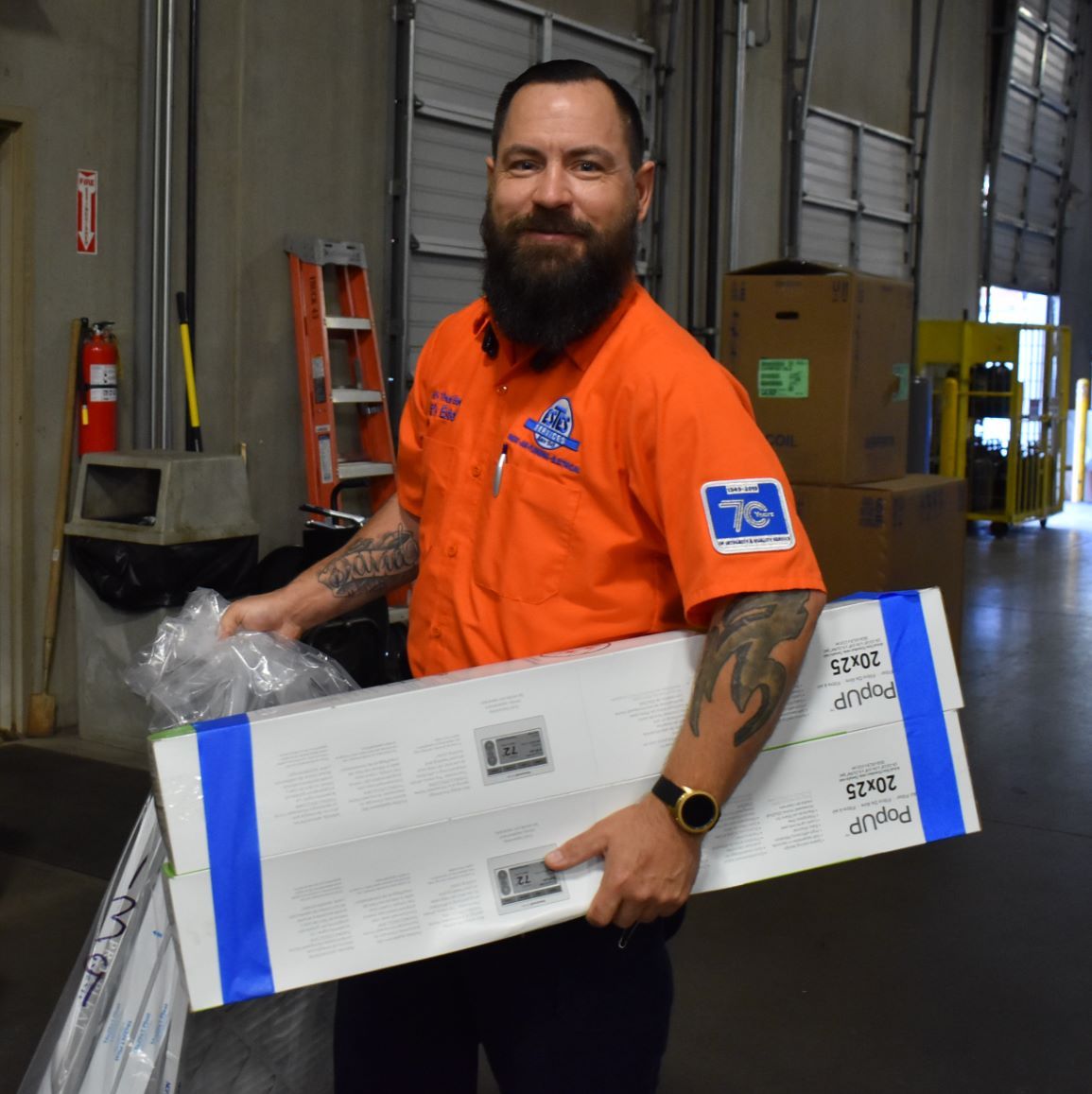 Estes Heating and AC Repairman holding air filters