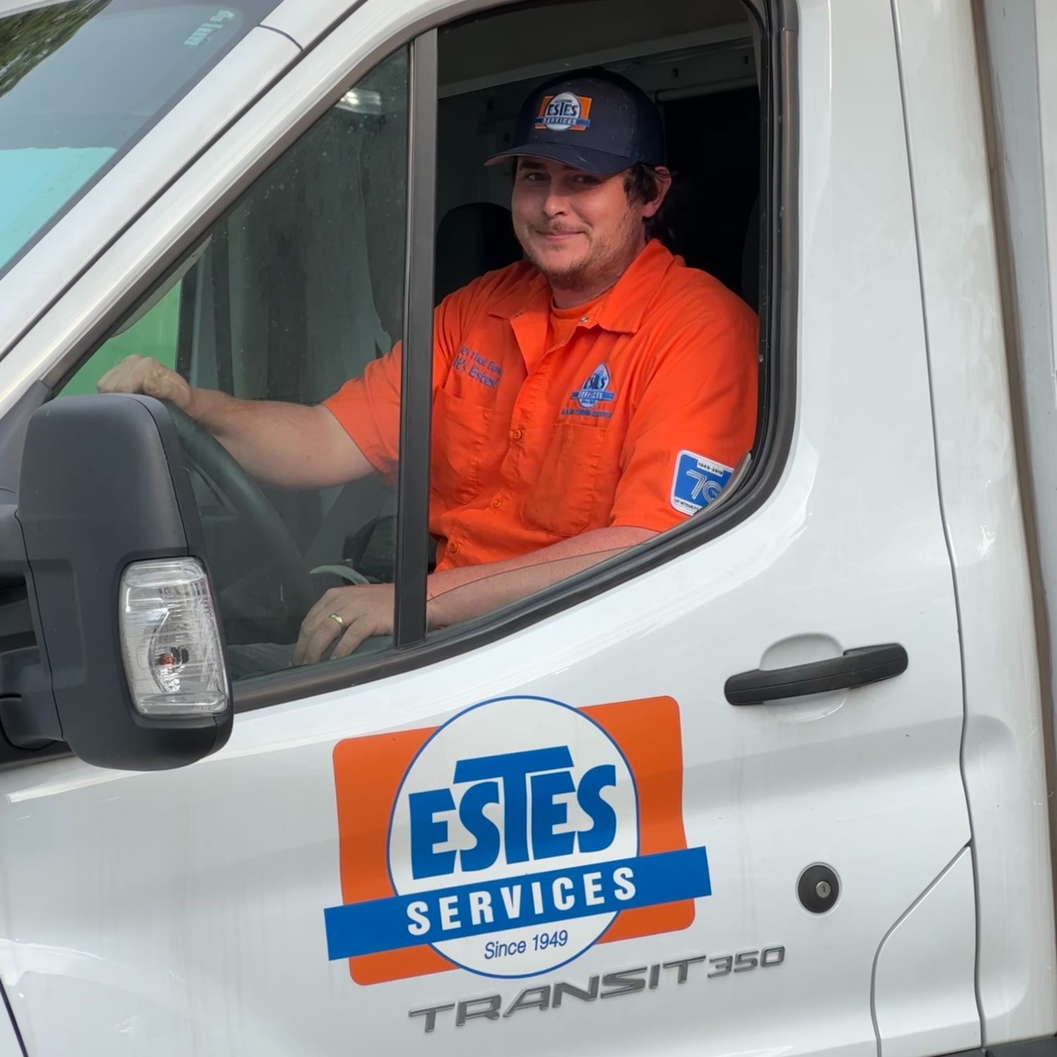 Estes plumber wearing a uniform and driving an Estes Services Truck