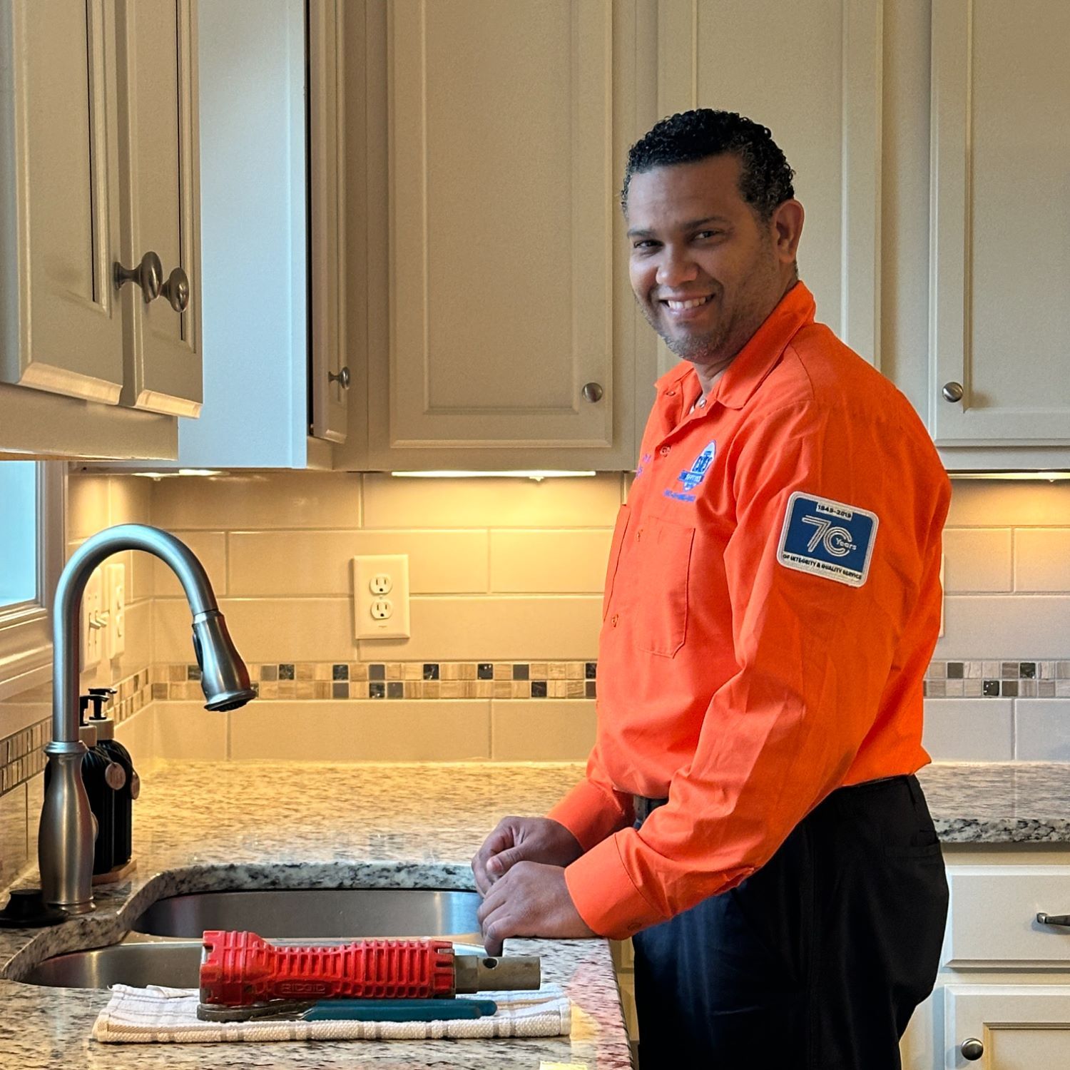 Estes Plumber in front of a sink, fixing a drain clogged