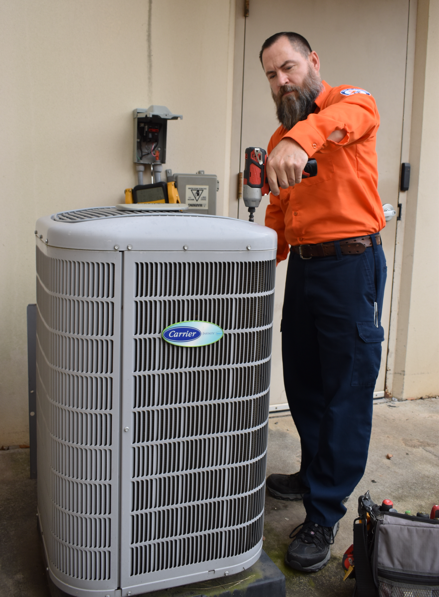 Estes Services Technician working on a Carrier Heat Pump