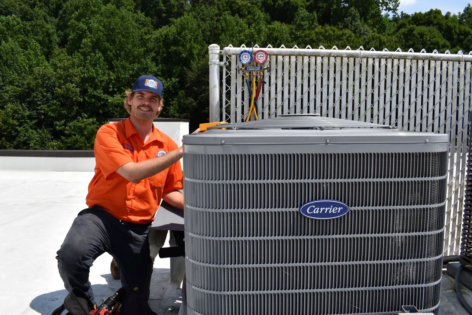 Estes Services HVAC Pro close to a Carrier Heat Pump in a rooftop