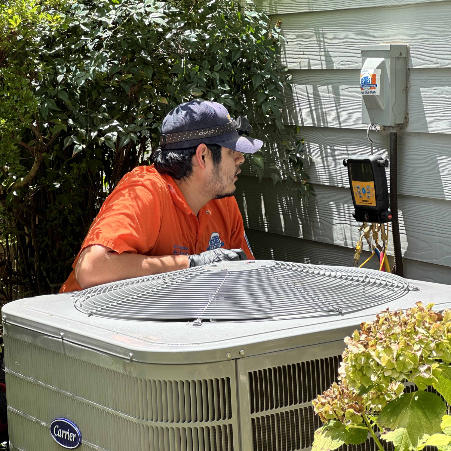 Estes Services Technician performing a Tune Up to an AC outdoor unit