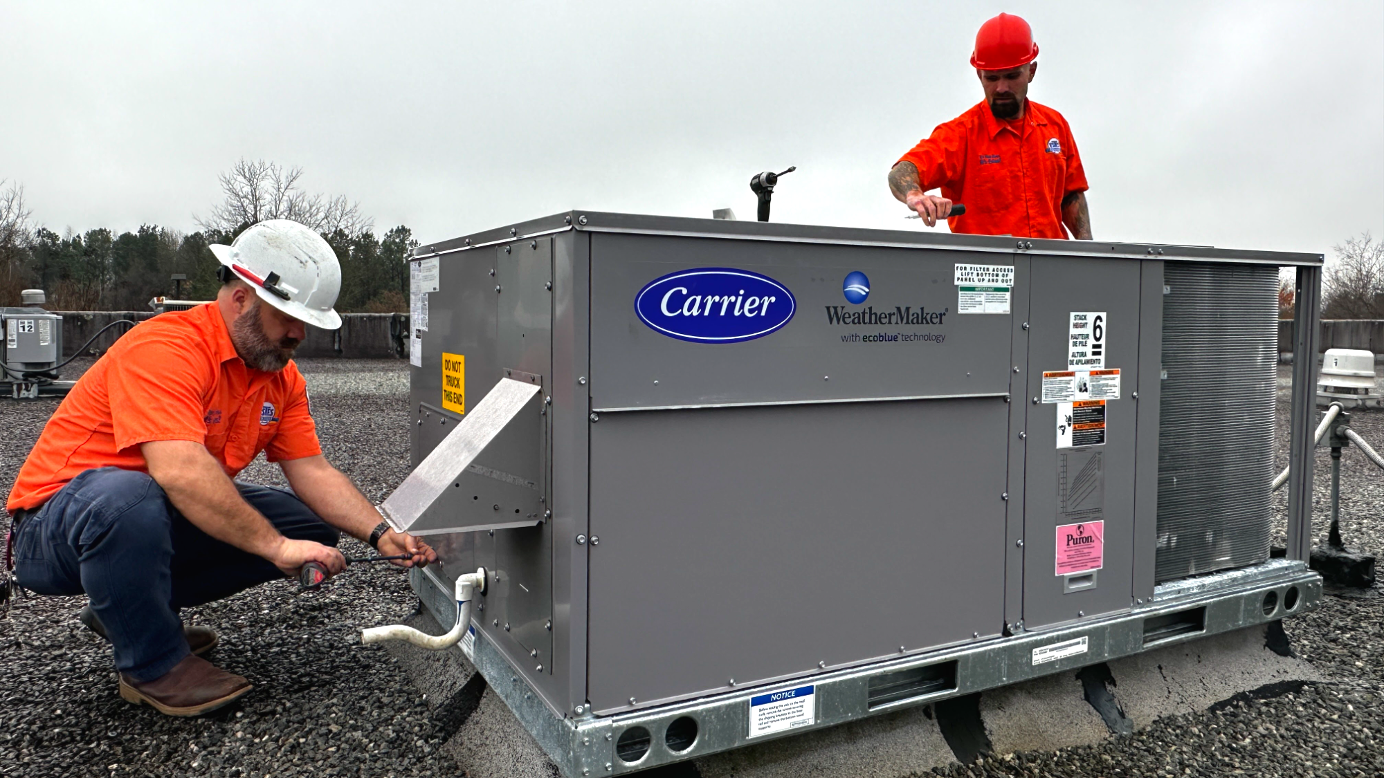 Estes Commercial Technicians working on a Carrier HVAC Commercial equipment