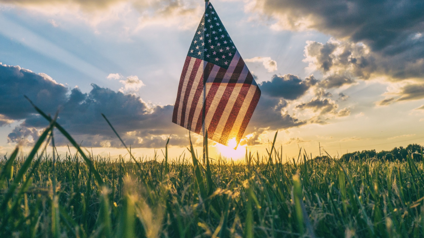 American flag in grassy field during sunset